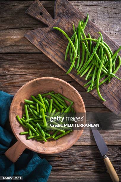 haricots verts coupés au couteau sur table en bois rustique - haricot vert photos et images de collection