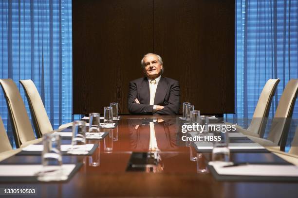 confident senior businessman sitting in conference room - conference table and chairs stock pictures, royalty-free photos & images