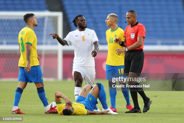 Franck Kessie of Team Ivory Coast interacts with Match Referee, Ismail Elfath during the Men's First Round Group D match between Brazil and Cote...
