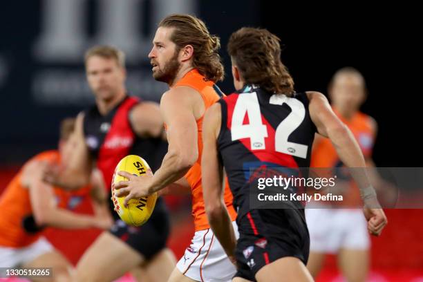 Callan Ward of the GWS Giants runs with the ball during the round 19 AFL match between Essendon Bombers and Greater Western Sydney Giants at Metricon...