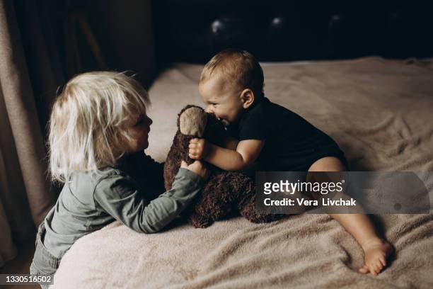 two children play at home on the bed - funny baby photo stock pictures, royalty-free photos & images