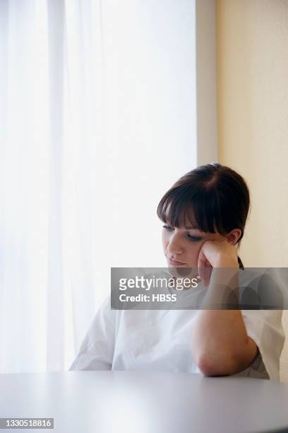 frustrated nurse leaning on table in hospital - pessimisme stock pictures, royalty-free photos & images