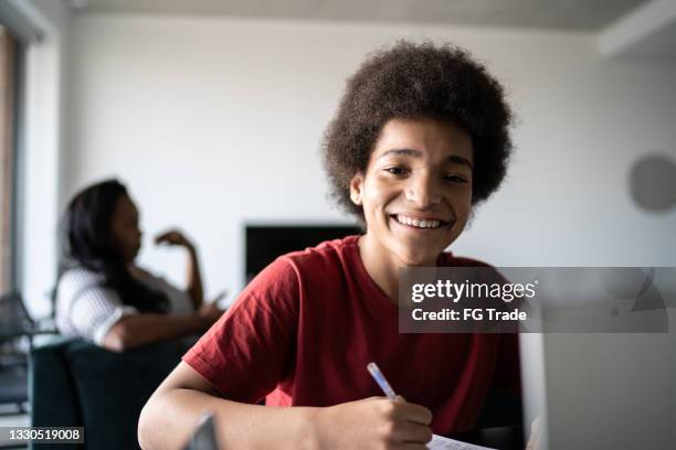 portrait of a happy teenager boy studying at home - junior high student stock pictures, royalty-free photos & images