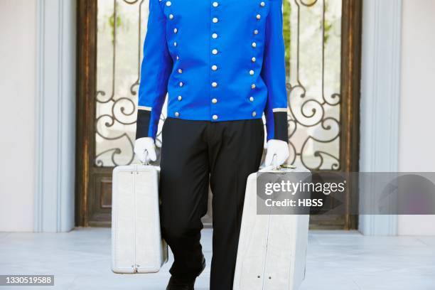 porter carrying luggage in luxury hotel - porter stock pictures, royalty-free photos & images