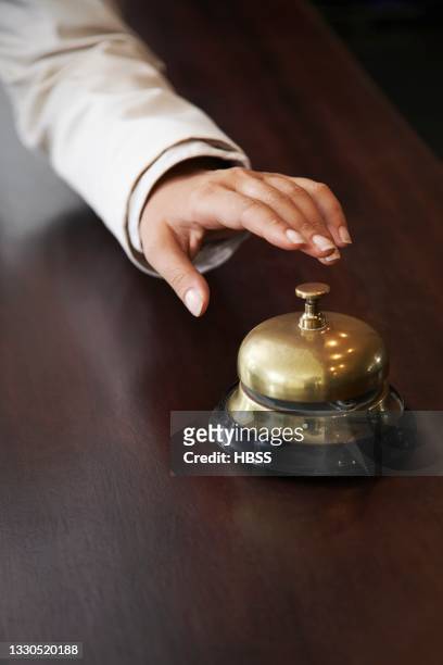 close-up of hand over service bell at reception - hotel bell stockfoto's en -beelden