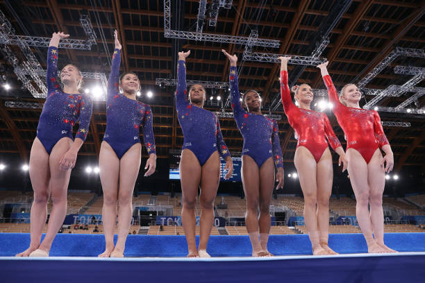 Grace McCullum, Sunisa Lee, Jordan Chiles, Simone Biles, Mykayla Skinner and Jade Carey of Team USA wave as they line up ahead of their floor...