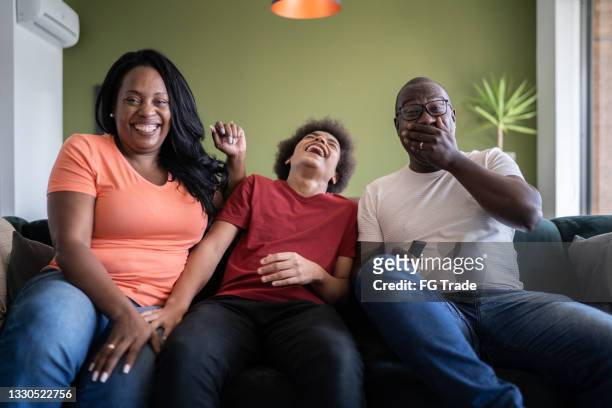 happy family together watching tv at home - guardians of heritage screening by german tv channel history stockfoto's en -beelden