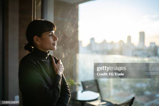 junge frau, die zu hause nachdenkt - mental wellbeing stock-fotos und bilder