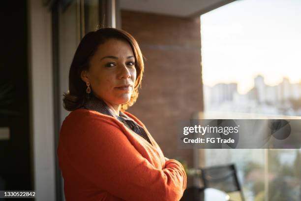 portrait of a mature woman by the window at home - vida real imagens e fotografias de stock