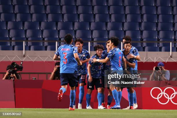 Ritsu Doan of Team Japan celebrates with team mates after scoring their side's second goal during the Men's First Round Group A match between Japan...