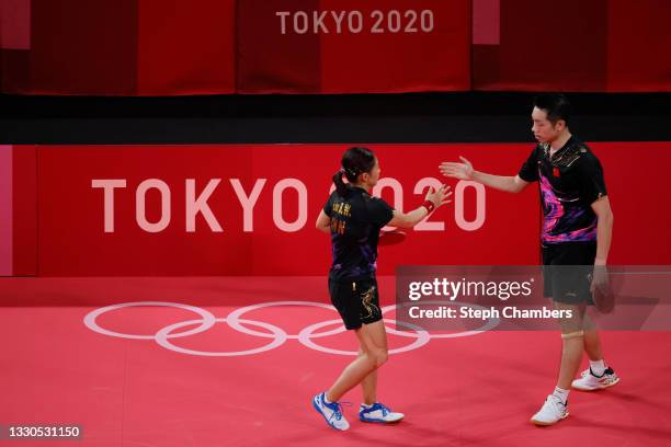 Liu Shiwen and Xu Xin of Team China shake hands during their Mixed Doubles Semifinal match on day two of the Tokyo 2020 Olympic Games at Tokyo...