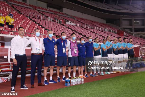 Mirel Radoi, Head Coach of Romania stand for the national anthem with his staff and players prior to the Men's First Round Group B match between...