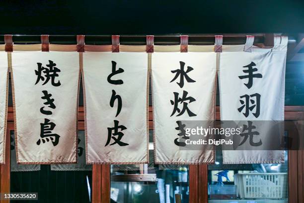 food menu on noren curtain - japanese script - fotografias e filmes do acervo