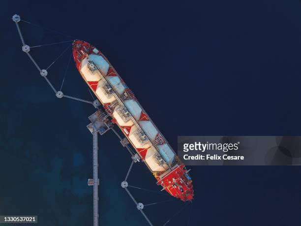 aerial view of an lng tanker supplying liquified natural gas to the power station. - gas tank stockfoto's en -beelden