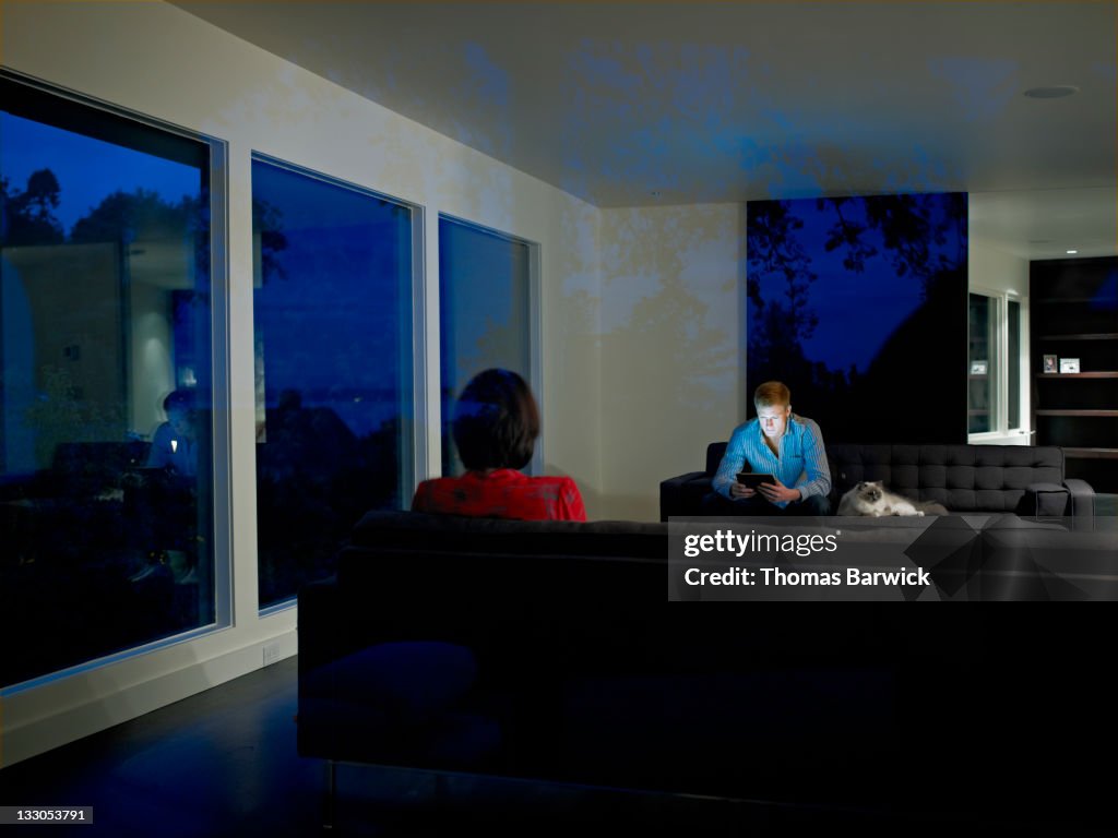 Couple sitting on couches in living room of home