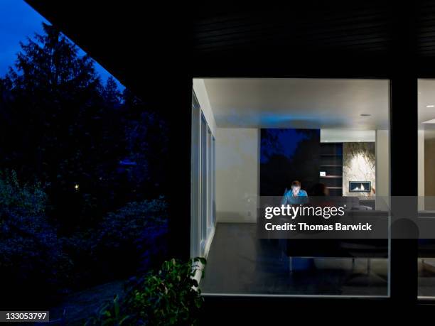 Husband and wife couple sitting in home at night