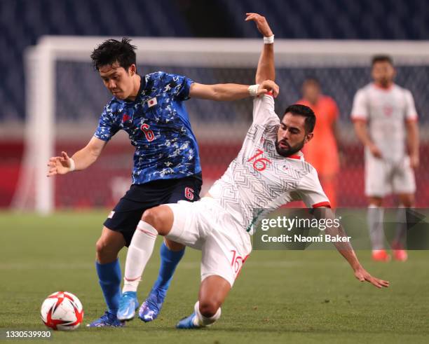 Wataru Endo of Team Japan is challenged by Joaquin Esquivel of Team Mexico during the Men's First Round Group A match between Japan and Mexico on day...