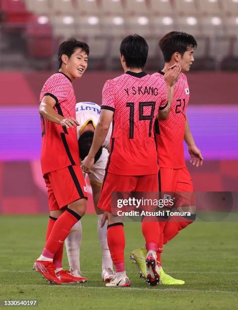 Kangin Lee of Team South Korea celebrates with teammates Yoonseong Kang and Jingyu Kim after scoring their side's fourth goal during the Men's First...