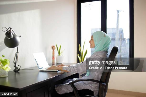 young hijab asian woman, shopping online, using laptop, isolation period - ジャカルタ ストックフォトと画像