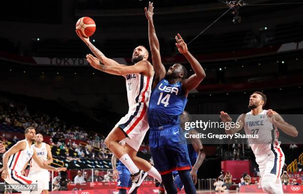 Evan Fournier of Team France goes up for a shot over Draymond Green of Team United States during the second half of the Men's Preliminary Round Group...