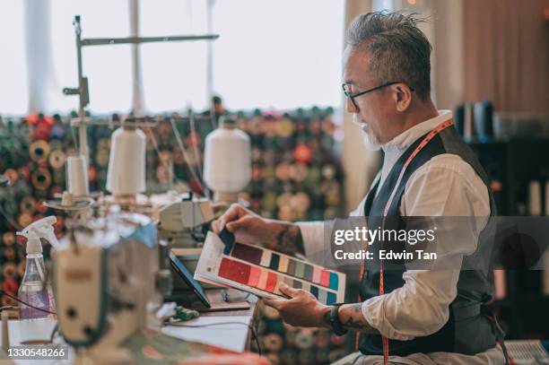 side view asian chinese senior man showing variation textile fabric swatch catalog video call customer with digital tablet at his studio - fabric swatches stock pictures, royalty-free photos & images