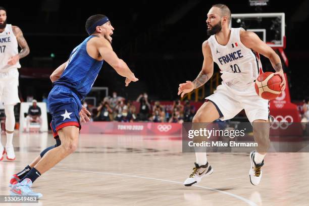 Evan Fournier of Team France looks to drive past Devin Booker of Team United States during the second half of the Men's Preliminary Round Group B...