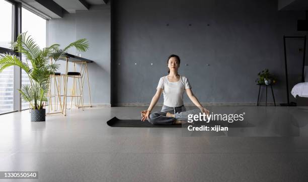 young woman practicing yoga meditation - hot yoga stock pictures, royalty-free photos & images