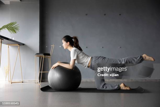 young woman doing yoga using ball - gym excercise ball stock pictures, royalty-free photos & images