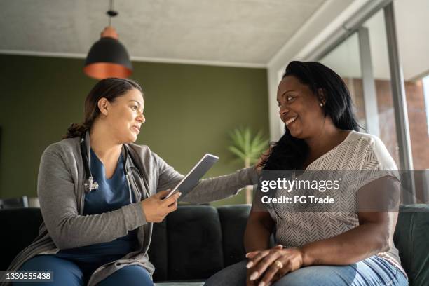 doctor talking to patient during home visit - patience stock pictures, royalty-free photos & images