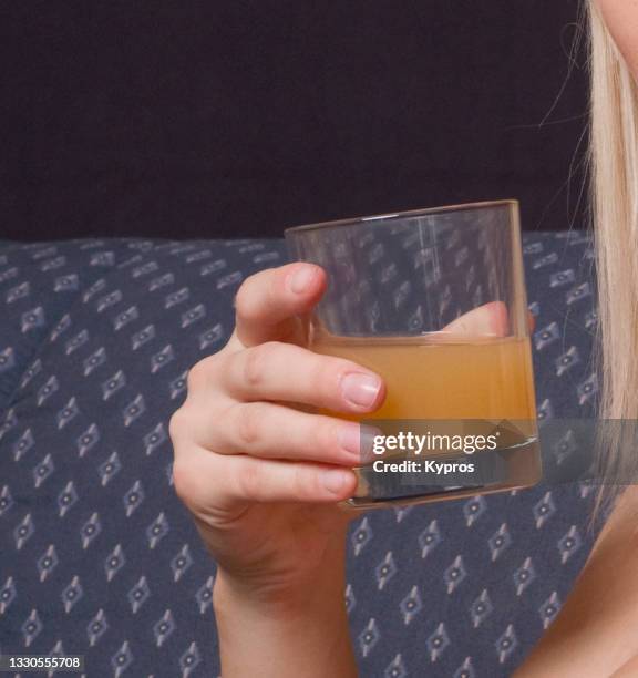 woman's hand holding a glass of fruit juice - apple juice stock pictures, royalty-free photos & images