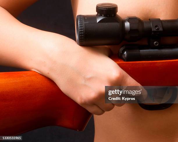 young woman holding a gun - hand holding gun stockfoto's en -beelden