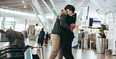 Man hugging woman after arriving from trip at airport