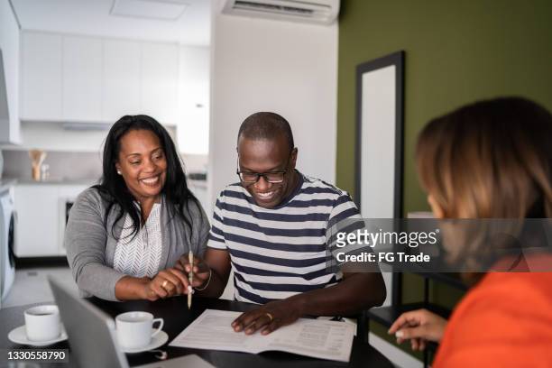 couple on a meeting with financial advisor or real estate agent - couple signing stock pictures, royalty-free photos & images