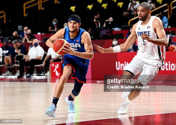 Devin Booker of the USA looks to pass during the preliminary rounds of the Men's Basketball match between the USA and France on day two of the Tokyo...
