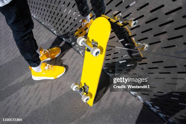 boy standing by skateboard and metal wall - skate reflections stock pictures, royalty-free photos & images