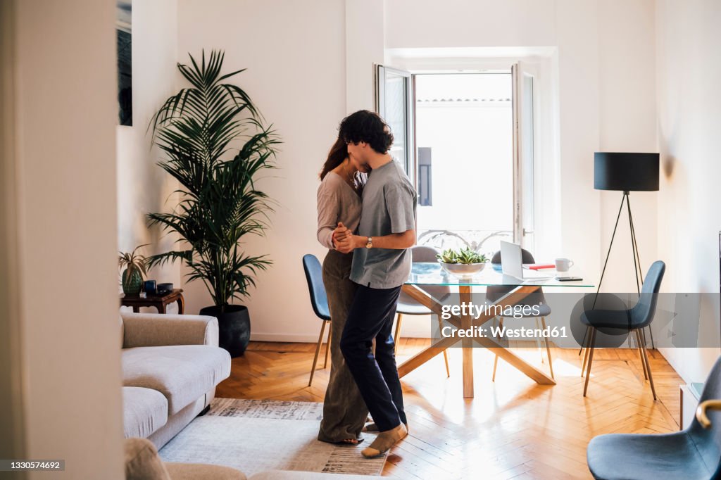Couple doing romance while standing in living room