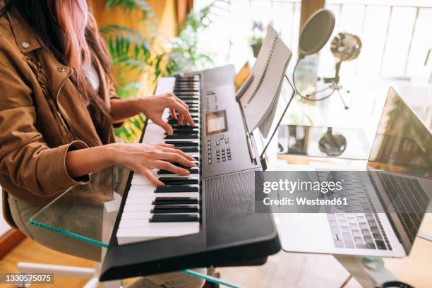 female musician playing electric piano at home - electric piano stock pictures, royalty-free photos & images
