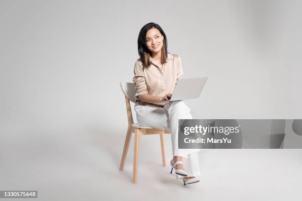 portrait of beautiful woman using laotop - stoel stockfoto's en -beelden