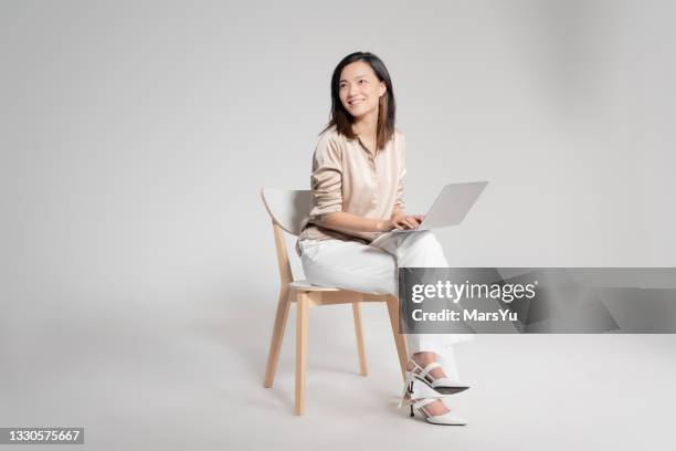 portrait of beautiful woman using laotop - chairs in studio stock pictures, royalty-free photos & images