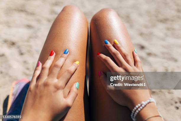 woman with colorful nail polish enjoying sunny day at beach - smalto per unghie foto e immagini stock