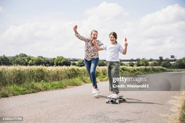 woman cheering for girl on skateboard on road - kid cheering stock pictures, royalty-free photos & images