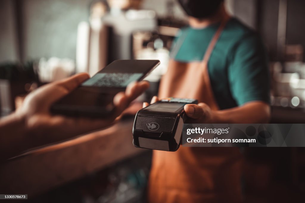 Smartphone QR code payment with credit card reader machine at the cafe
