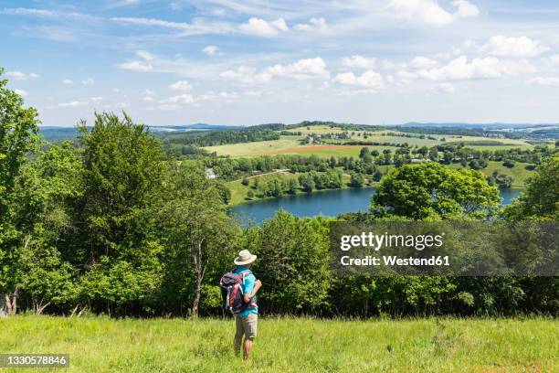 senior hiker admiring landscape surrounding weinfelder maar lake - volcanic crater stock pictures, royalty-free photos & images