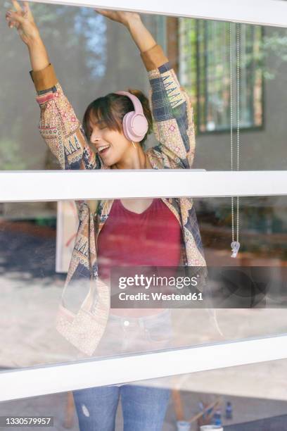 female painter dancing near window in studio - completamente desabrochado fotografías e imágenes de stock