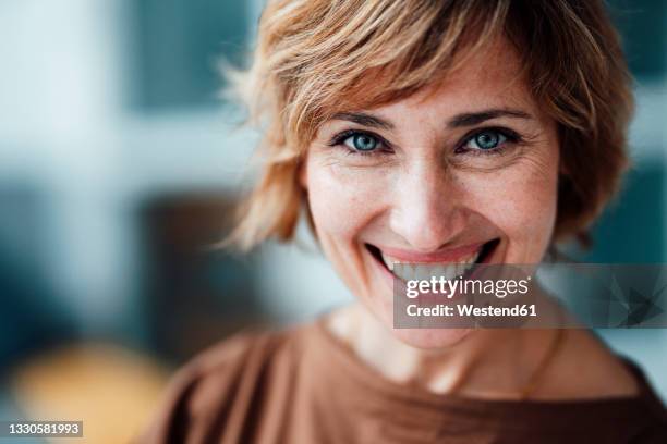 smiling businesswoman in office - stralende lach stockfoto's en -beelden