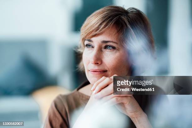 thoughtful businesswoman with hands clasped in office - brood stock pictures, royalty-free photos & images