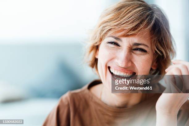 businesswoman laughing in office - frauen stock-fotos und bilder