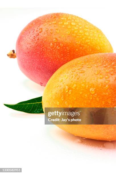 delicious ripe mango with green on white. - mangoes stock pictures, royalty-free photos & images