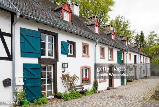 germany, north rhine-westphalia, kronenburg, row of rustic houses along cobblestone street in historic medieval village - eifel stock pictures, royalty-free photos & images