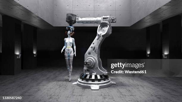 three dimensional render of gynoid held by robotic arm inside industrial factory - robotic arm stock illustrations